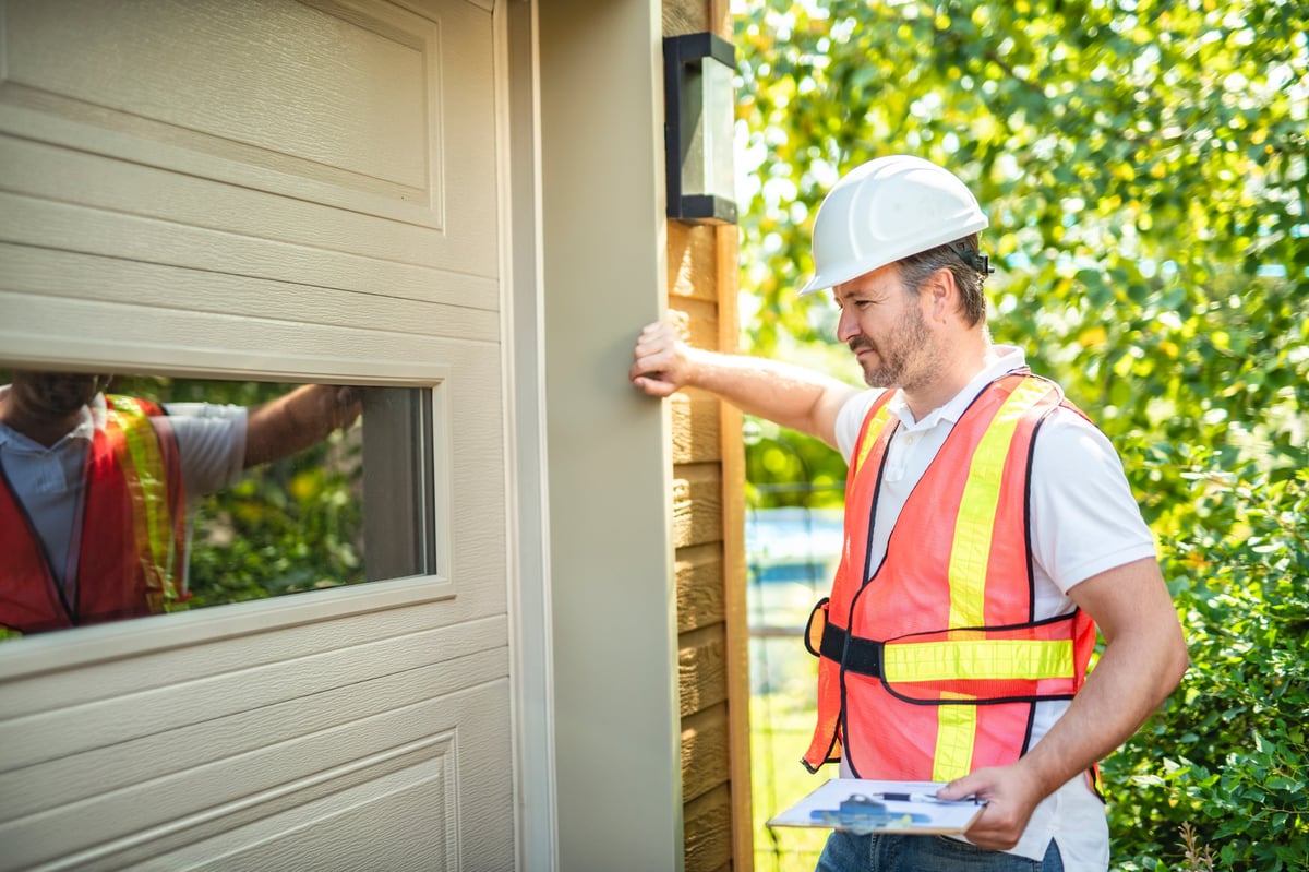 Professional inspector examining a garage door mechanism