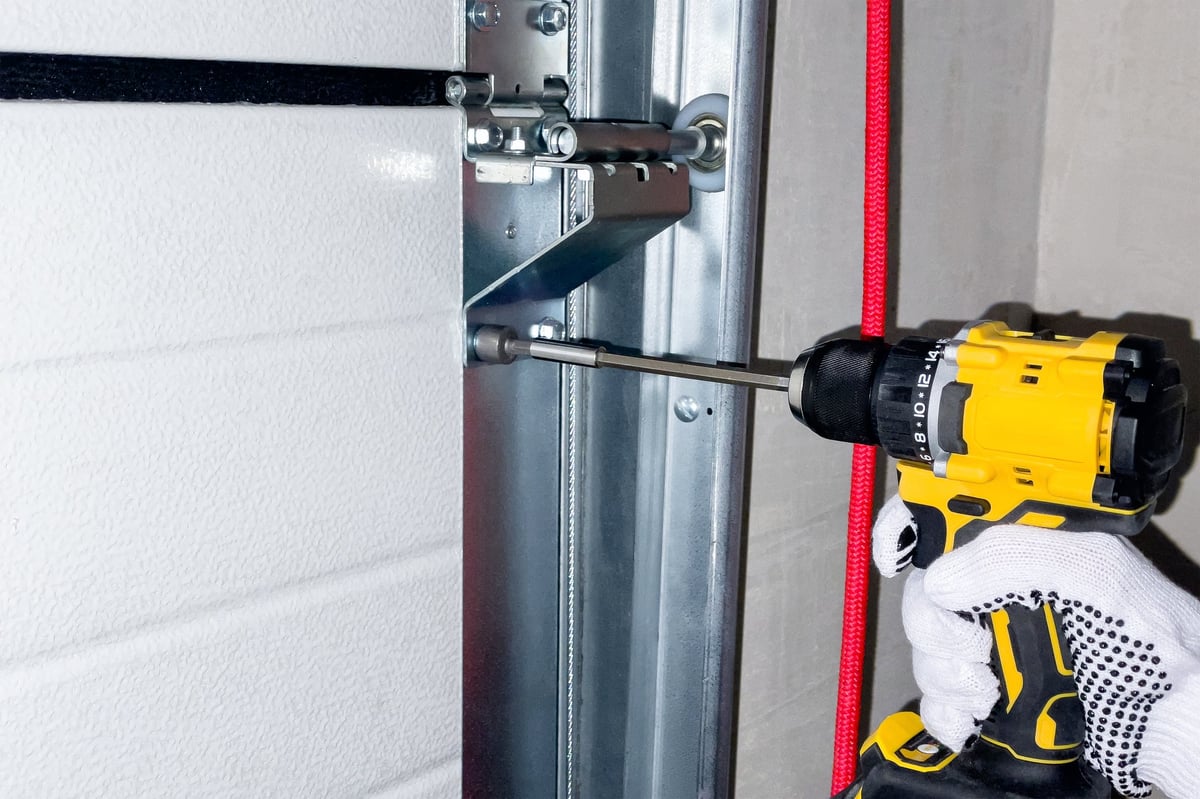 Professional installation of sectional garage door rails requiring expert tools and training