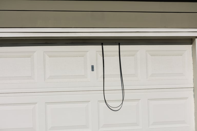 Garage door with broken mechanism showing unbalanced door