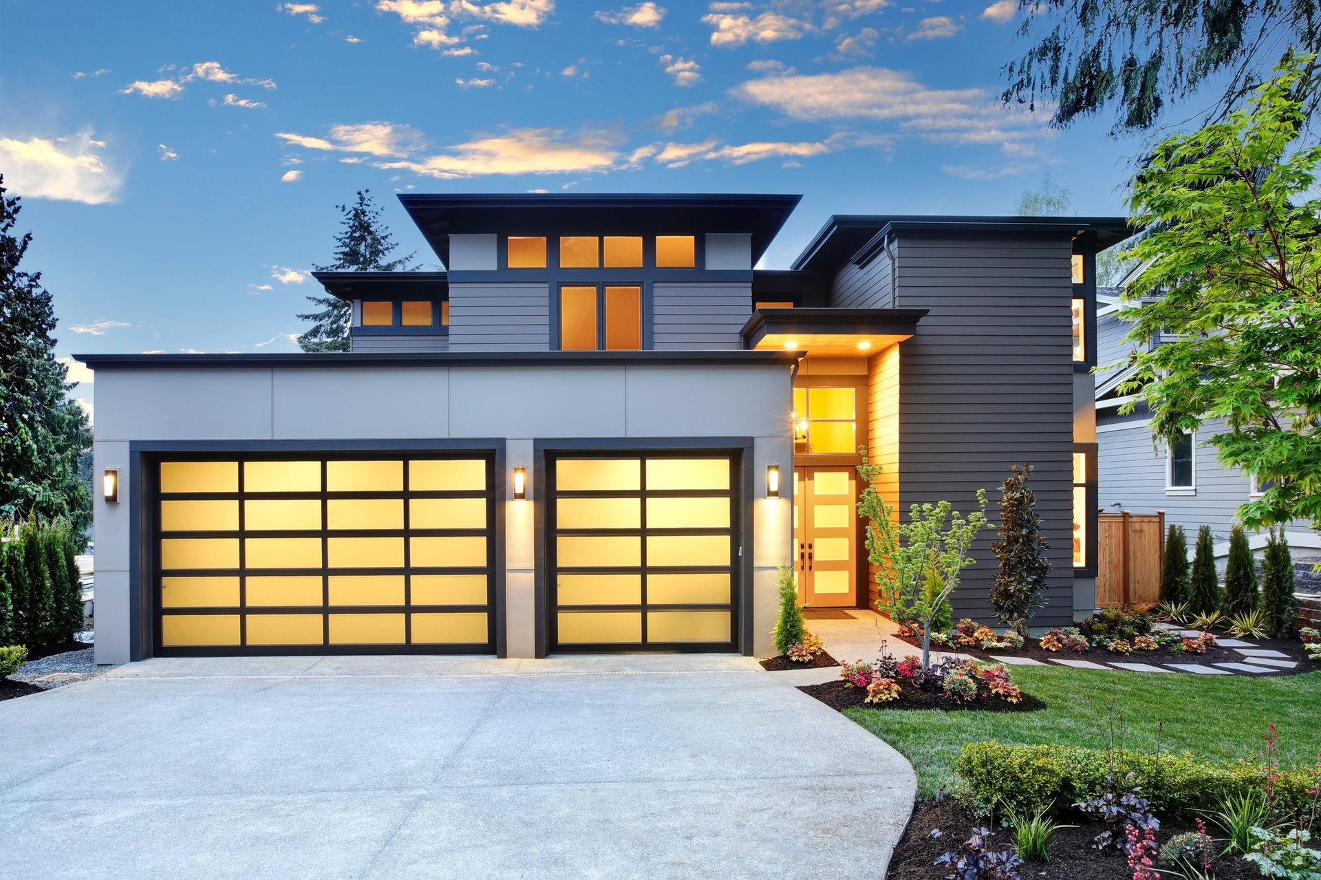 Contemporary home with glass garage door at sunset