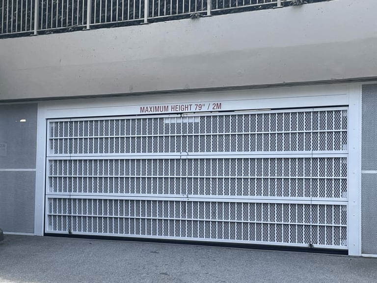 White modern garage door with vertical slat pattern installed on residential building entrance