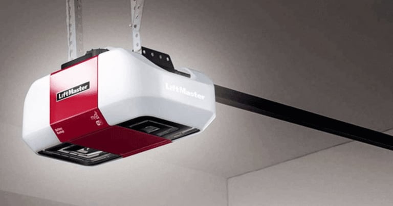 Red and white automatic garage door opener mounted on ceiling with black metal bracket