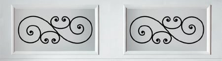 Two decorative wrought iron scrollwork panels with ornate spiral designs in white frames