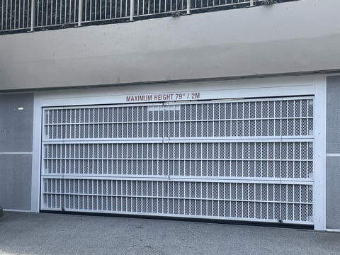 White garage door with vertical grid pattern and maximum height marking on residential building