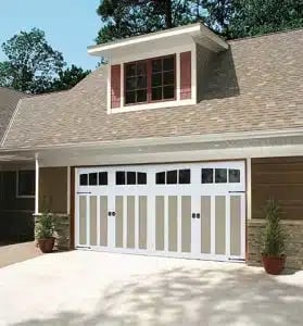 Two-story house with white garage doors, brick and siding exterior, and a front-facing gable window