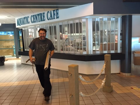 Man jogging past a closed cafe in an indoor shopping mall corridor