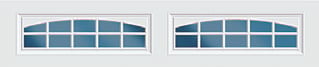 Two white garage doors with arched transom design and blue glass panes